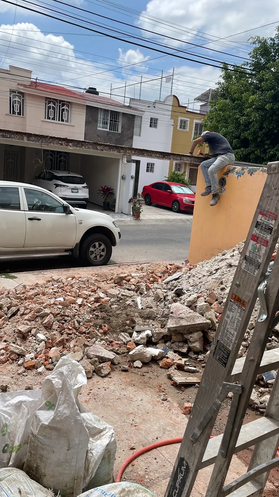 Retiro de una viga en la cochera con escombro en primer plano