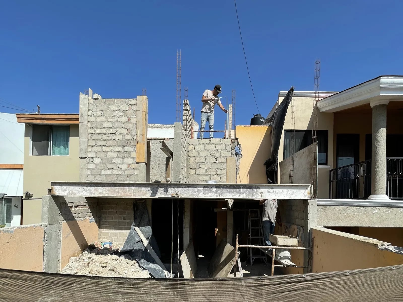 Ampliación de Casa Guadalupe en Zapopan: muros nuevos en la planta alta vistos desde la calle.